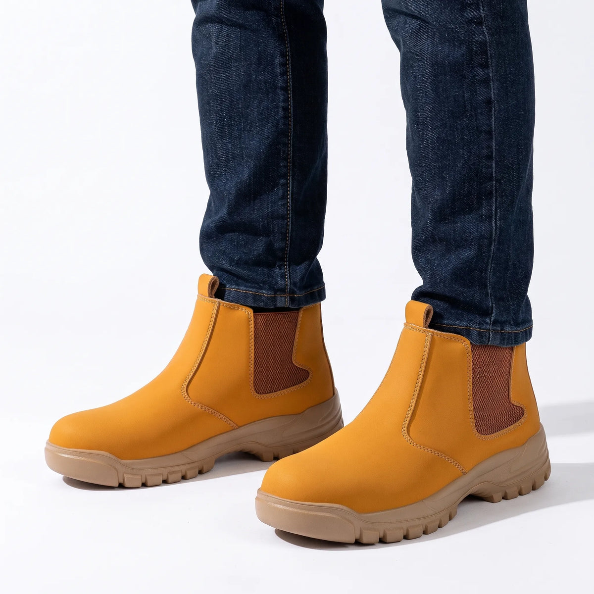 Tan slip-on boots with brown mesh panels, worn with dark blue jeans against a white background 16