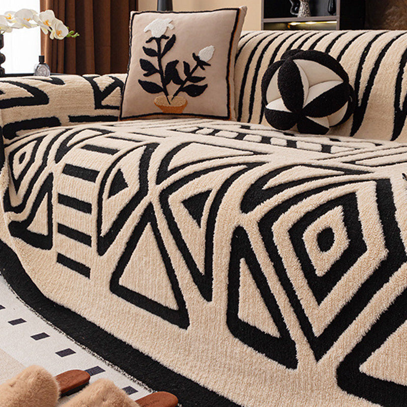Beige cover with black geometric triangle and diamond pattern on a sofa, with a plant-motif cushion 17