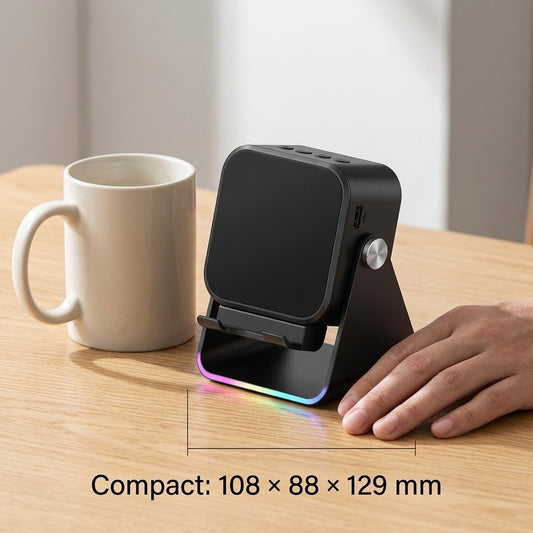 Black speaker stand from the front beside a mug, with a hand showing its compact size 2
