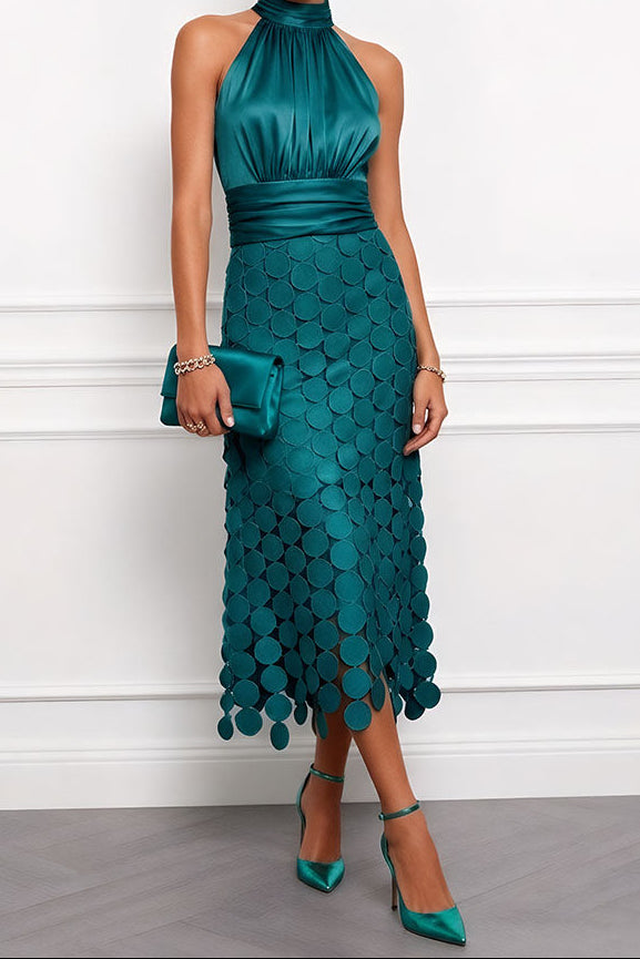 Model wears the halter midi dress in deep teal green with a ruched satin bodice, disc appliqué skirt and matching clutch and heels. 6