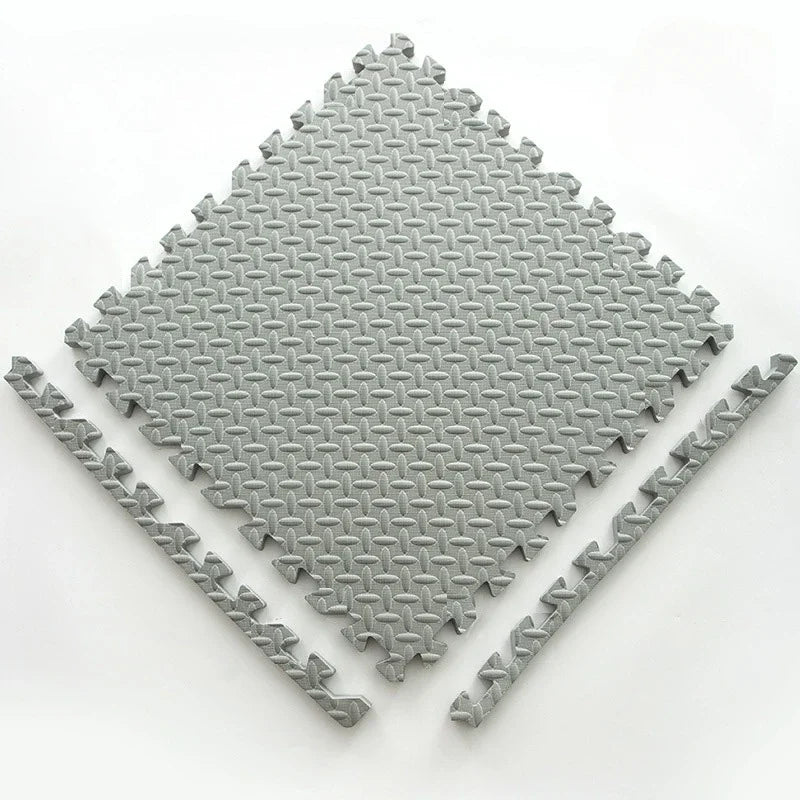 Single grey foam puzzle tile with a textured leaf pattern, shown flat with two separate border edge pieces. 18