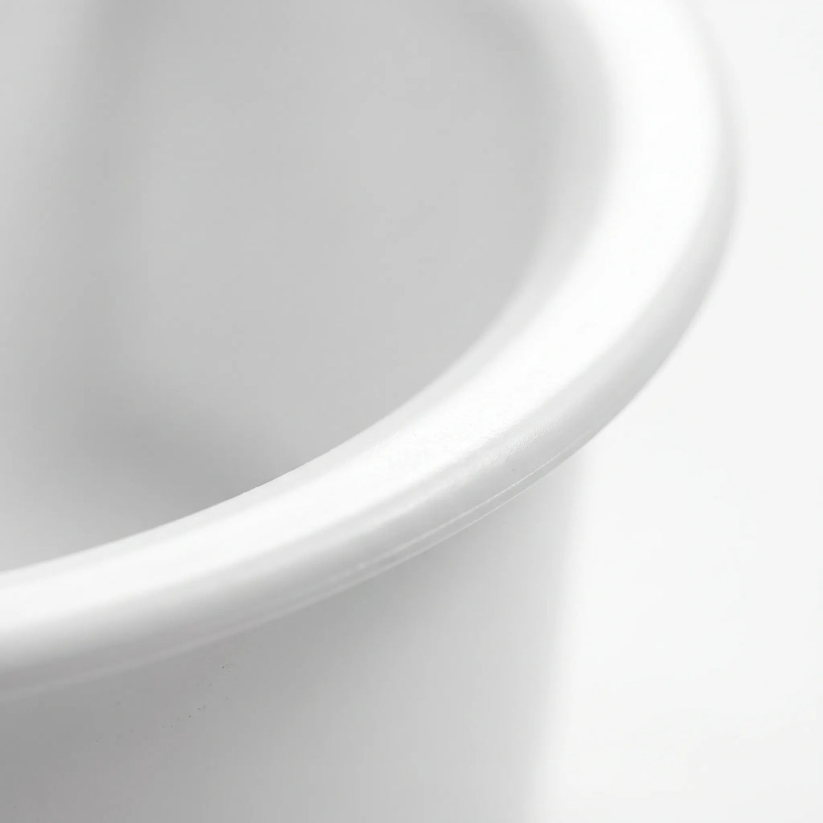 Close-up of the smooth, rounded rim of the white plastic bowl, showing the glossy finish and curved edge. 3