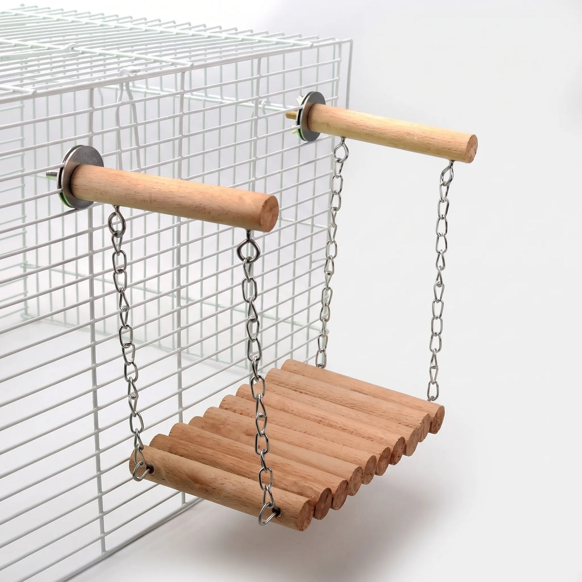 Plain wooden rung bridge hanging by chains from two bolted wooden perches on a white wire cage. 5
