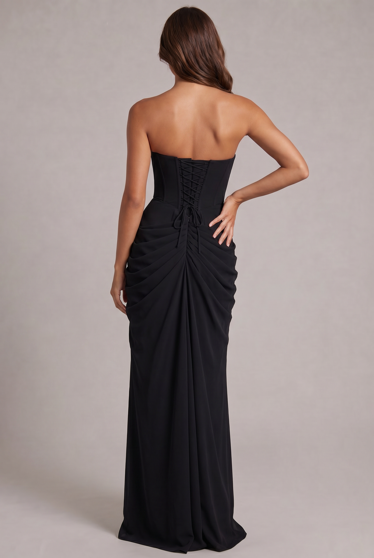 Back view of the black dress showing the corset lacing and ruched, floor-length skirt 28
