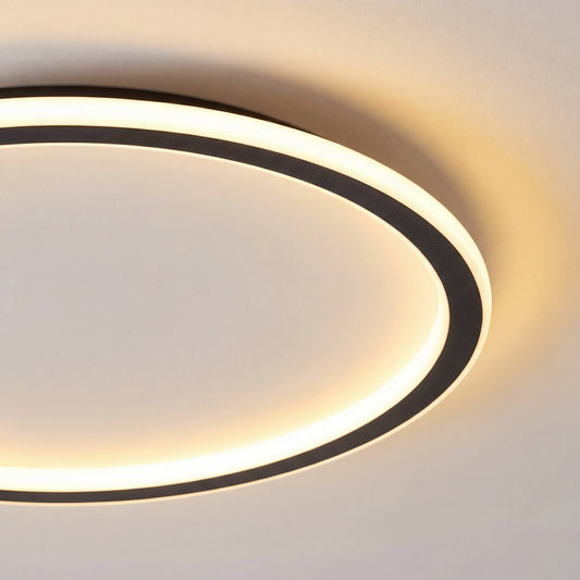 Close-up of part of the black ring frame and its glowing diffuser, showing the warm light spreading across the ceiling. 2