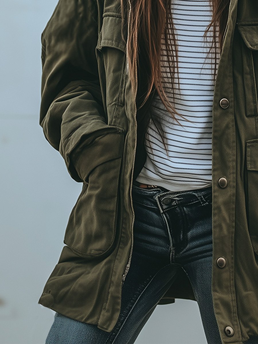 Close-up of the zip, deep lower pocket and relaxed sleeve of the jacket worn open over jeans. 4