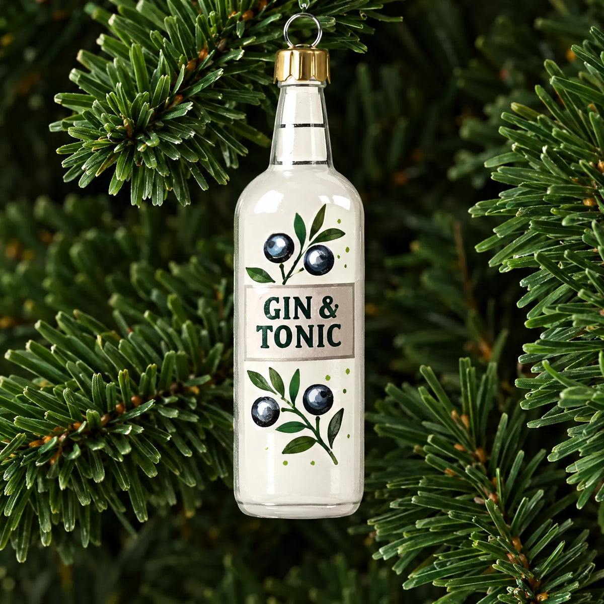 Close-up of a single clear miniature bottle ornament with a gold cap and blueberry design hanging among pine needles. 3