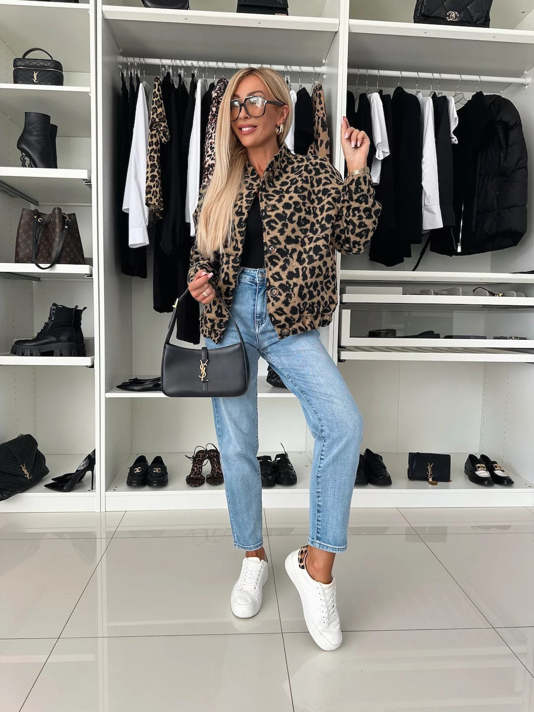 Full-length view of the leopard print bomber shacket styled with a black top, light blue jeans and white trainers in a dressing room. 5