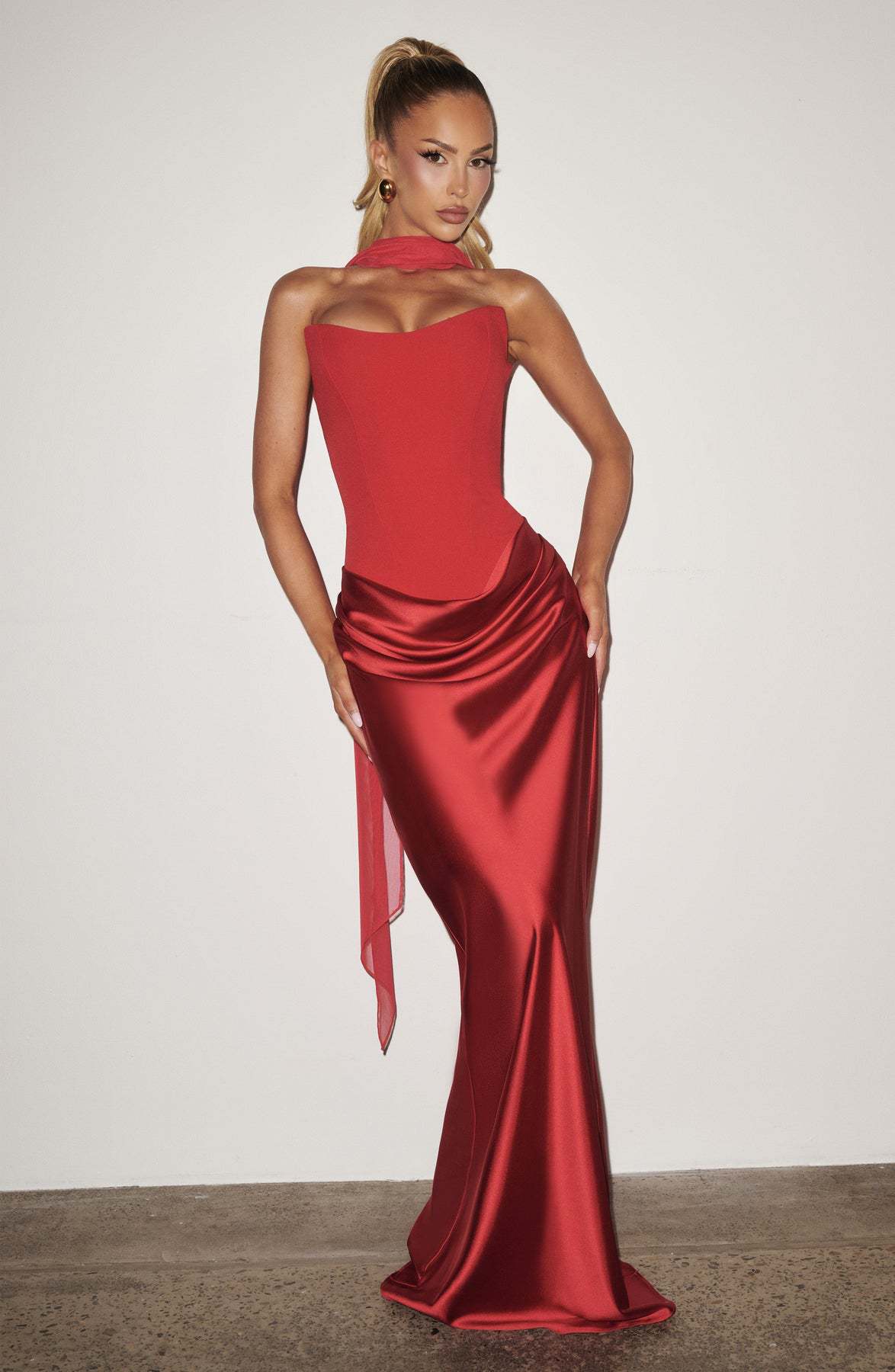 Full-length red dress worn by a model with a sheer scarf draped around the neck 31