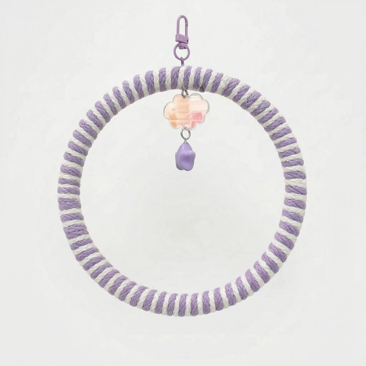 Ring swing wrapped in lilac and white striped rope, with a lilac clip, peach cloud charm and purple star bead. 7
