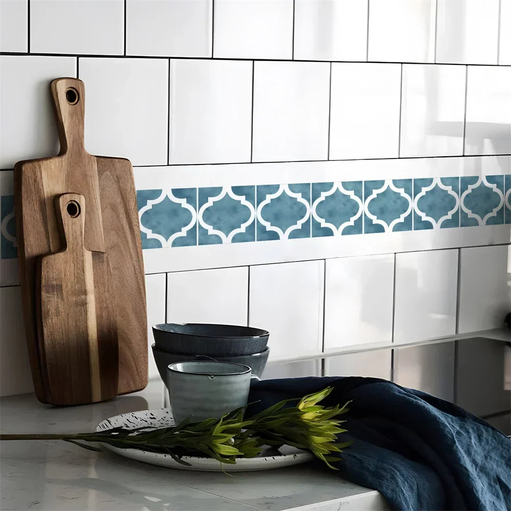 Blue lantern-pattern border strip across white kitchen wall tiles, with chopping boards and bowls below 64