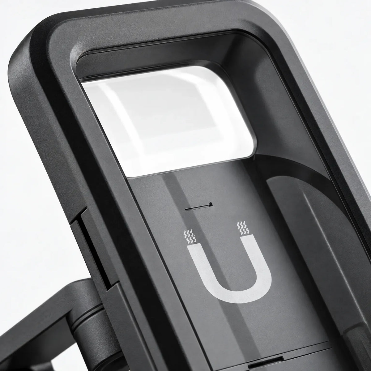 Close-up of the mount's black casing and clear window, with a magnet symbol on the back panel. 3