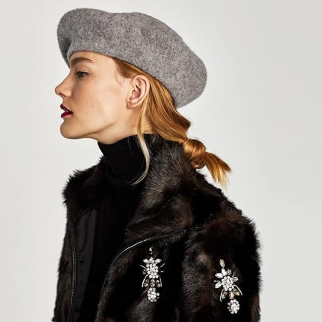 Grey wool beret in side profile on a model wearing a dark fur jacket 23