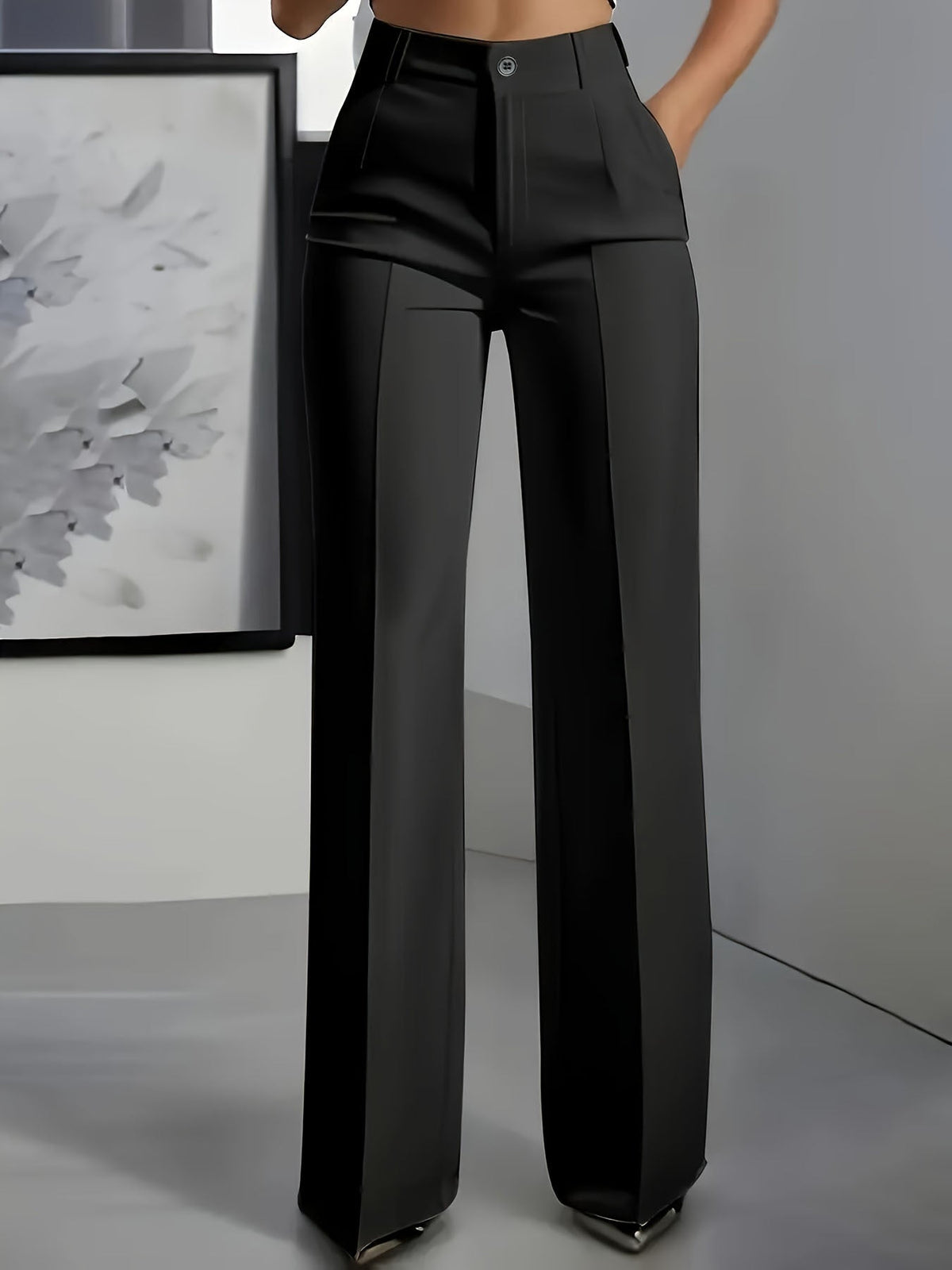 Front view of wide-leg trousers in black with a centre crease, worn with a hand in the pocket 8