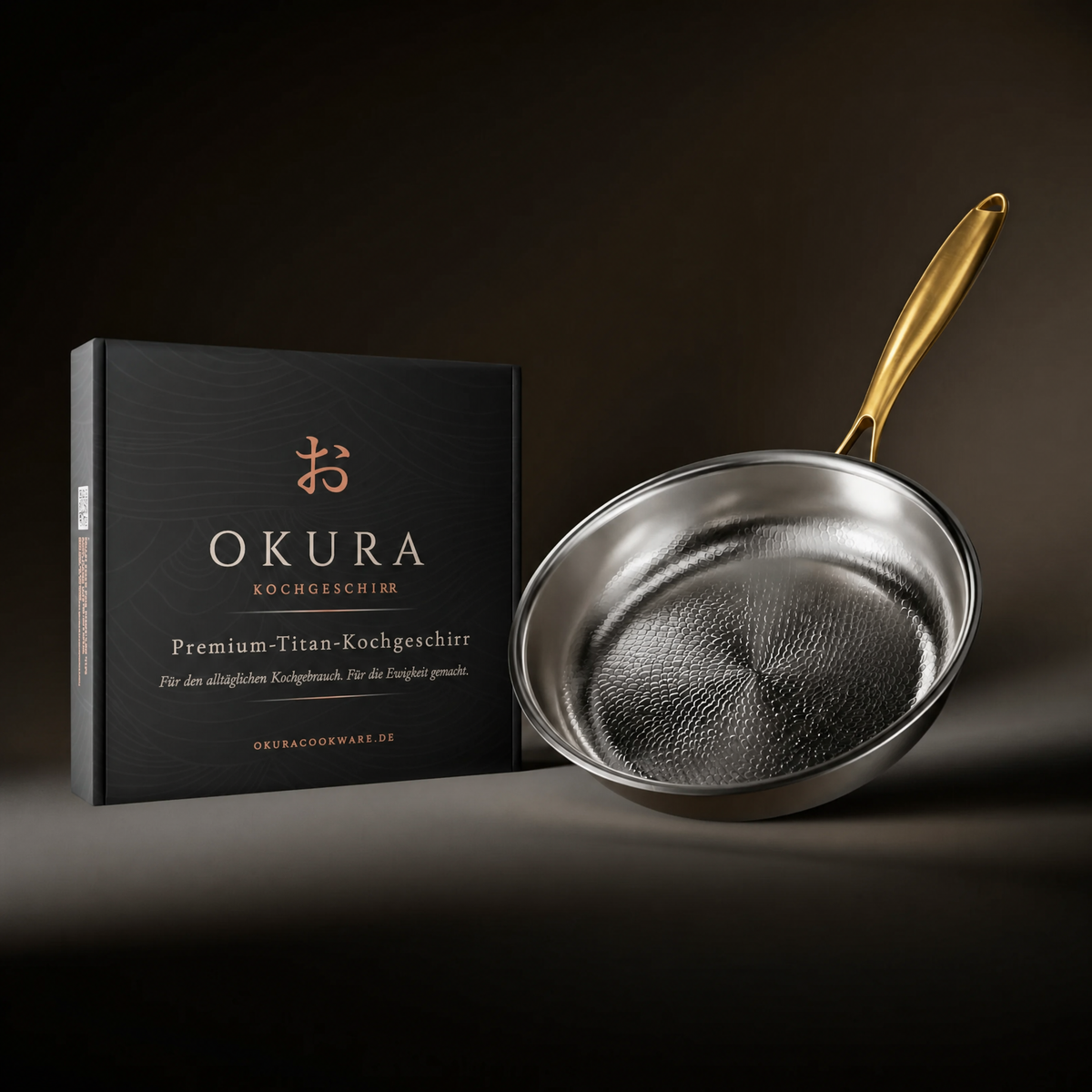 The hammered frying pan with gold handle leaning beside its black gift box, shown against a dark studio background. 8