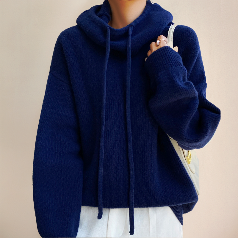 Navy blue knit jumper with drawstring cowl neck and loose sleeves, worn with white trousers and a cream handbag 9