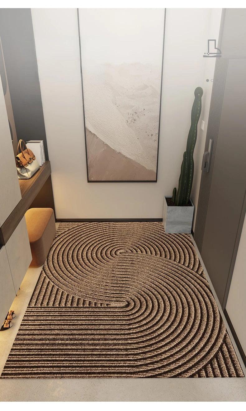 Brown doormat with large concentric semicircles and straight ridges, seen from above in a modern hallway with a cactus and wall art. 6