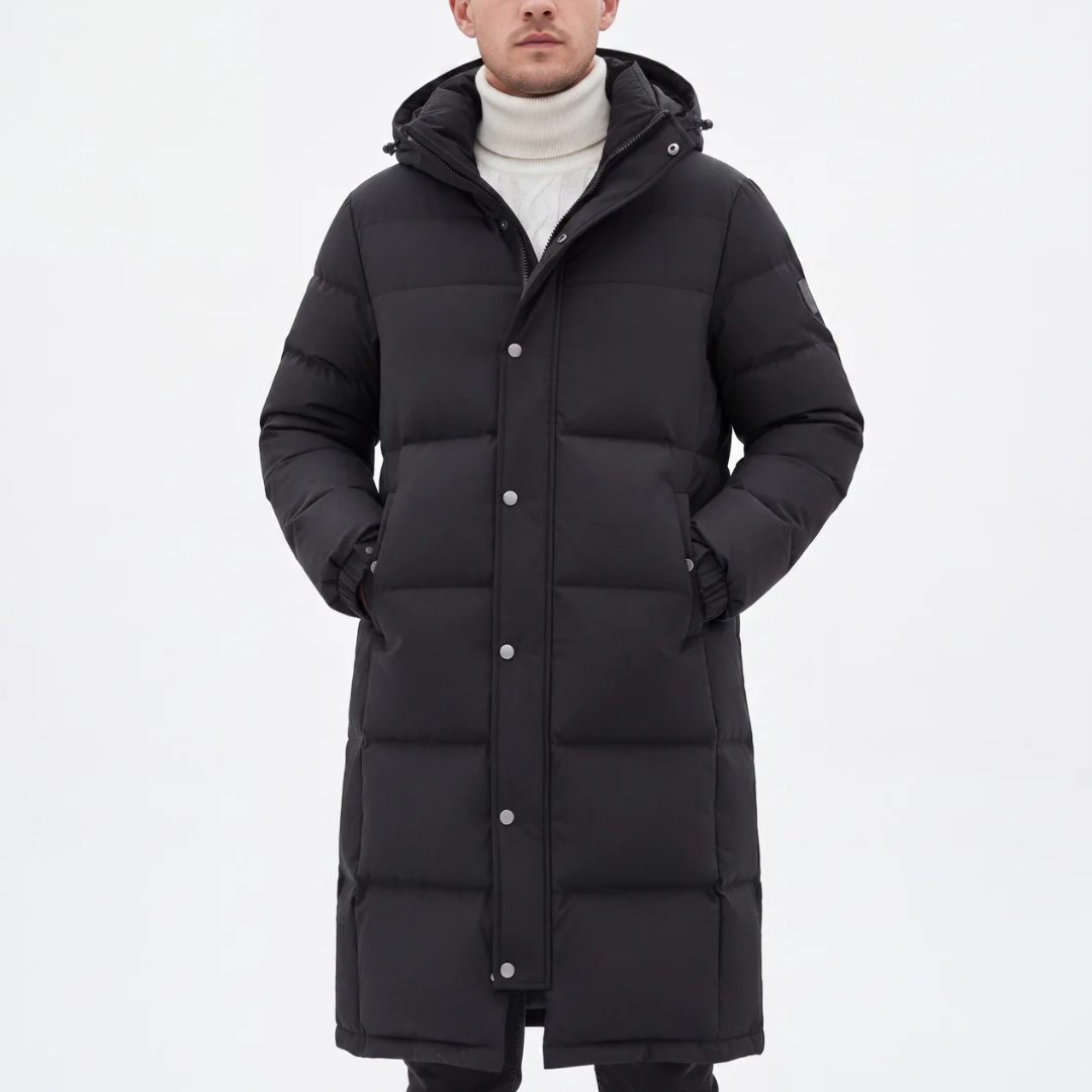 Model in the black long hooded puffer coat, hands in pockets, over a cream roll-neck jumper 7