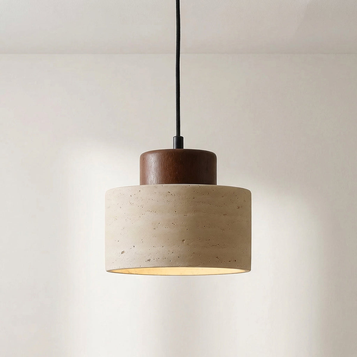 Close-up of the pitted travertine shade with a dark walnut-toned wooden cap and black cord 6