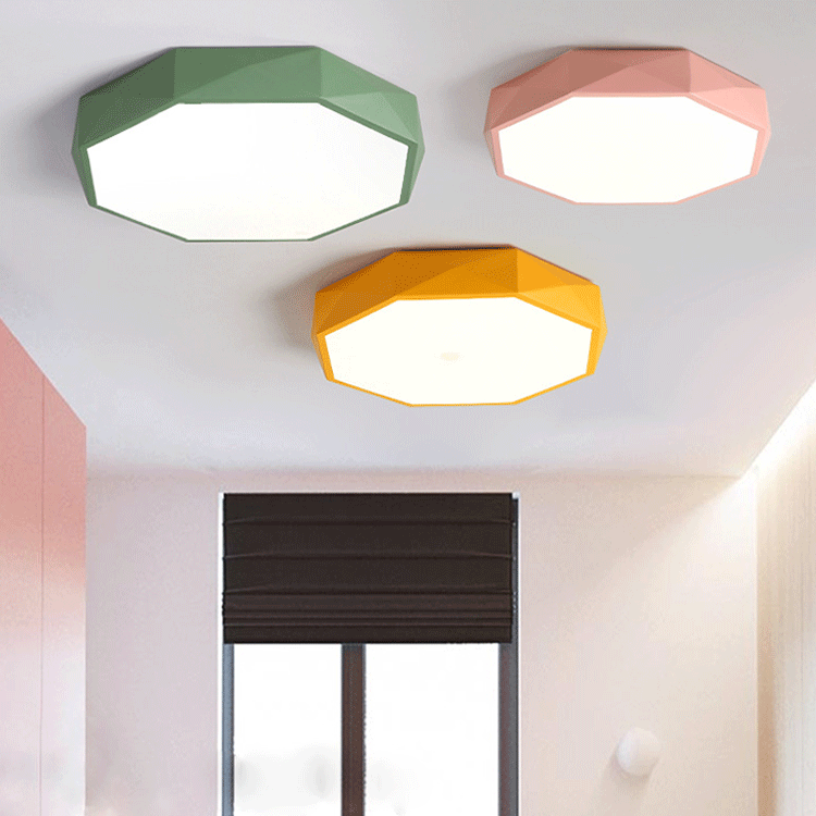 Green, pink and yellow faceted octagonal ceiling lights fitted together on a white ceiling above a window 1