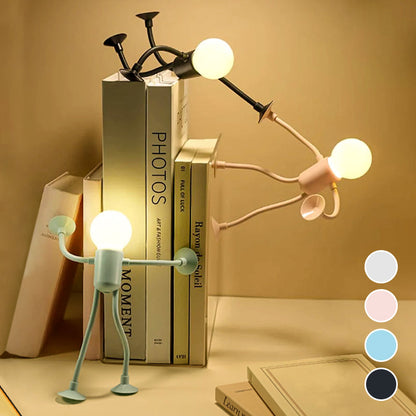 Glowing figure lamps in green, pink and black pose against a row of books, with four colour swatches at the corner. 5