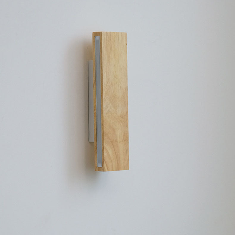 Vertical wooden bar light switched off, showing the frosted diffuser strip along its edge and the white wall bracket. 11