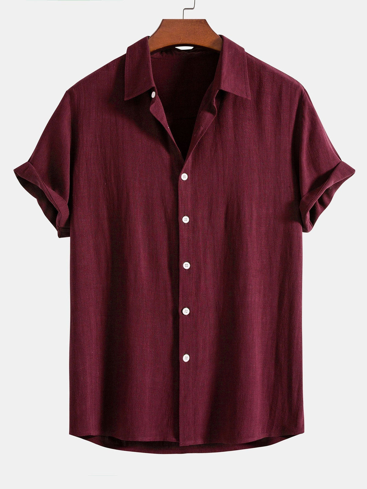 Short sleeve button-up shirt in deep burgundy on a wooden hanger, with white buttons down the placket. 7