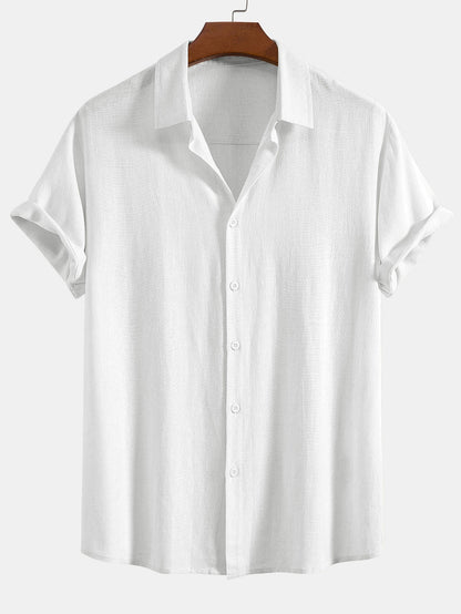 Short sleeve button-up shirt in white on a wooden hanger, showing the subtle woven texture and rolled sleeves. 6