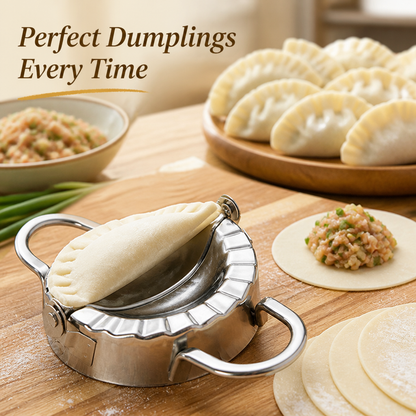 Steel dumpling mould on a wooden board holding a folded, crimped dumpling, with a plate of finished dumplings, filling and dough rounds behind. 1