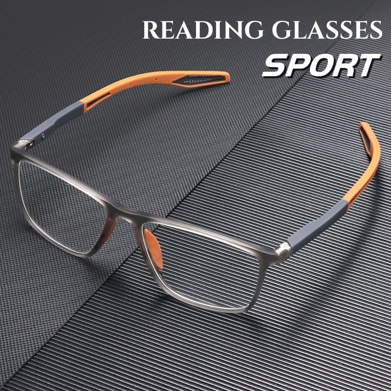 Square sport frames in translucent grey with orange and grey flexible arms, resting on a dark ridged surface. 1