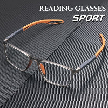 Square sport frames in translucent grey with orange and grey flexible arms, resting on a dark ridged surface. 1