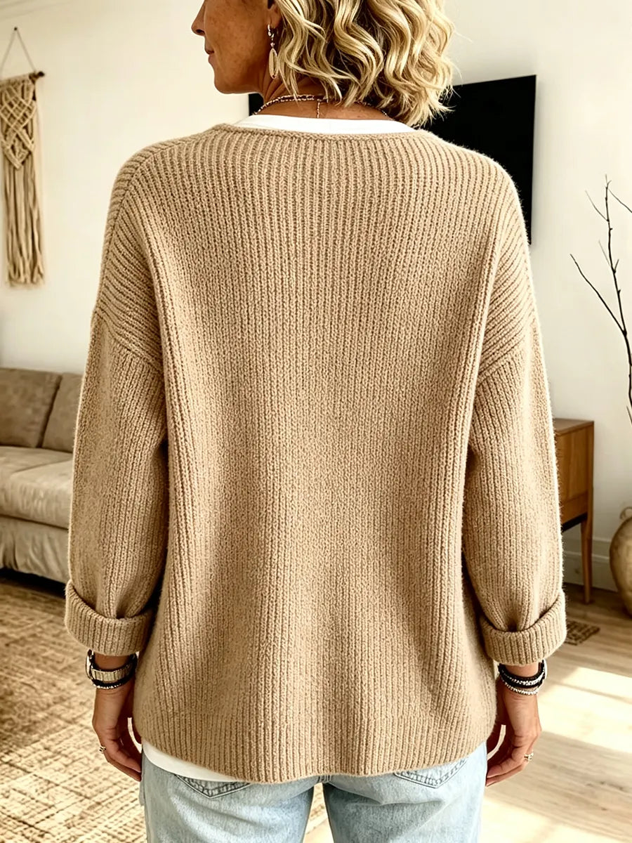 Back view of the camel ribbed cardigan on a model, showing the plain ribbed back and turned-up cuffs 2