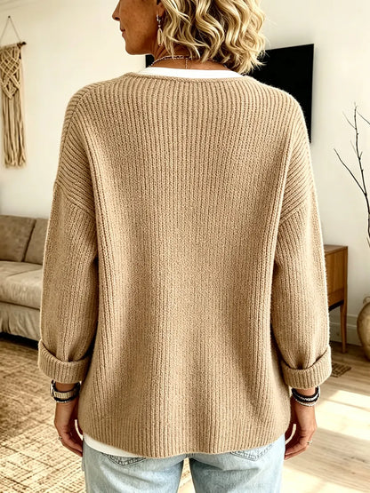Back view of the camel ribbed cardigan on a model, showing the plain ribbed back and turned-up cuffs 2