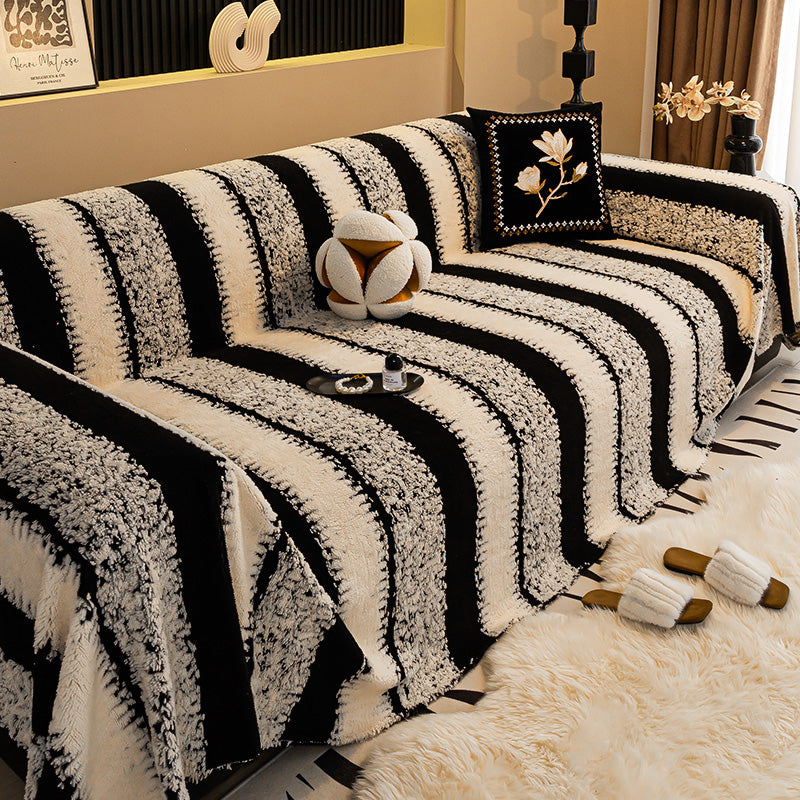 Cream and black striped textured cover on a sofa, with a floral cushion and fluffy slippers on a rug 9