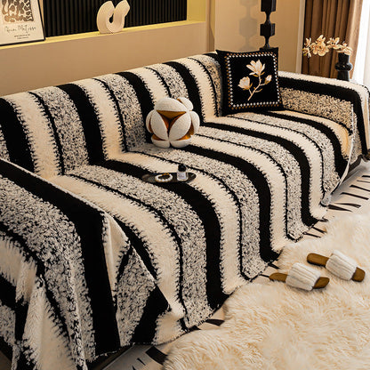 Cream and black striped textured cover on a sofa, with a floral cushion and fluffy slippers on a rug 9
