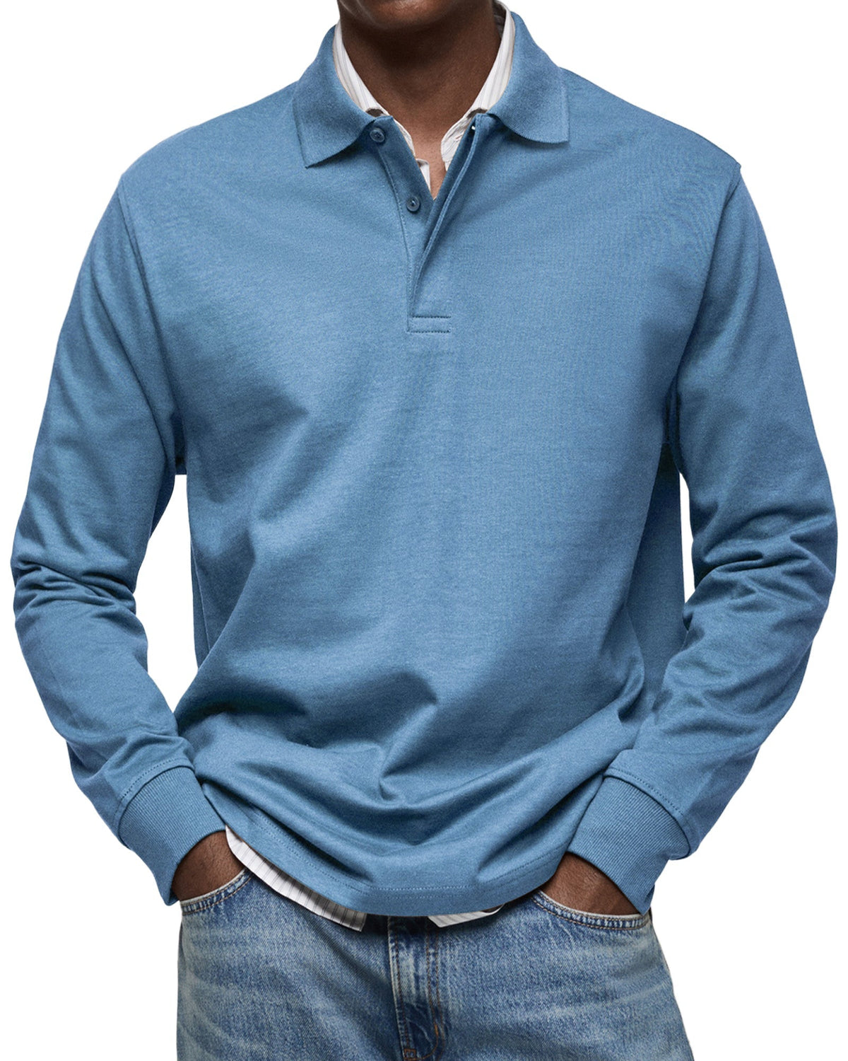 Front view of the long sleeve polo in dusty blue on a model, ribbed cuffs, hands in jeans pockets. 2