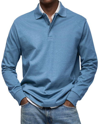 Front view of the long sleeve polo in dusty blue on a model, ribbed cuffs, hands in jeans pockets. 2