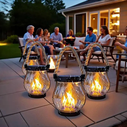 Three lit lanterns on a patio foreground while friends sit chatting around a table at dusk 5