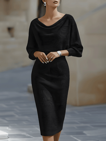 Model wearing the ribbed knit midi dress in black, front view, with draped neckline, batwing sleeves and fitted skirt. 1