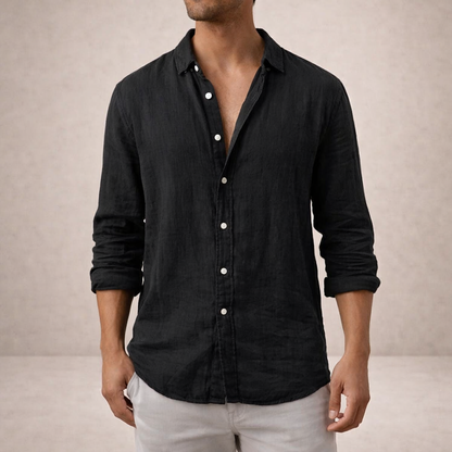 Black linen shirt worn by a model, cropped at the chin, with white buttons and sleeves rolled up. 5