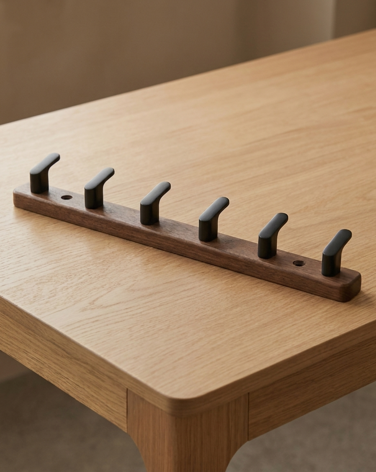 Six-hook version lying on an oak table, with two screw holes visible along the board 9