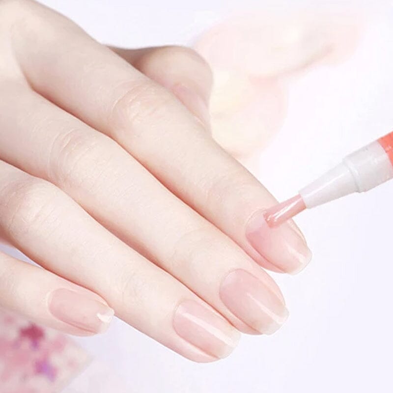 Close-up of hand with a pink pen brushing oil onto a nail 11