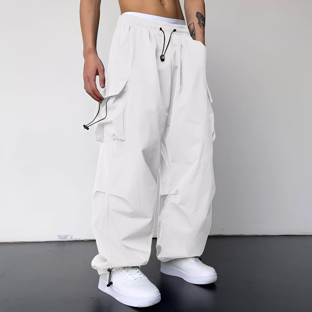 Model wears the baggy cargo trousers in white with white trainers, drawstring waist and cuffs visible 4