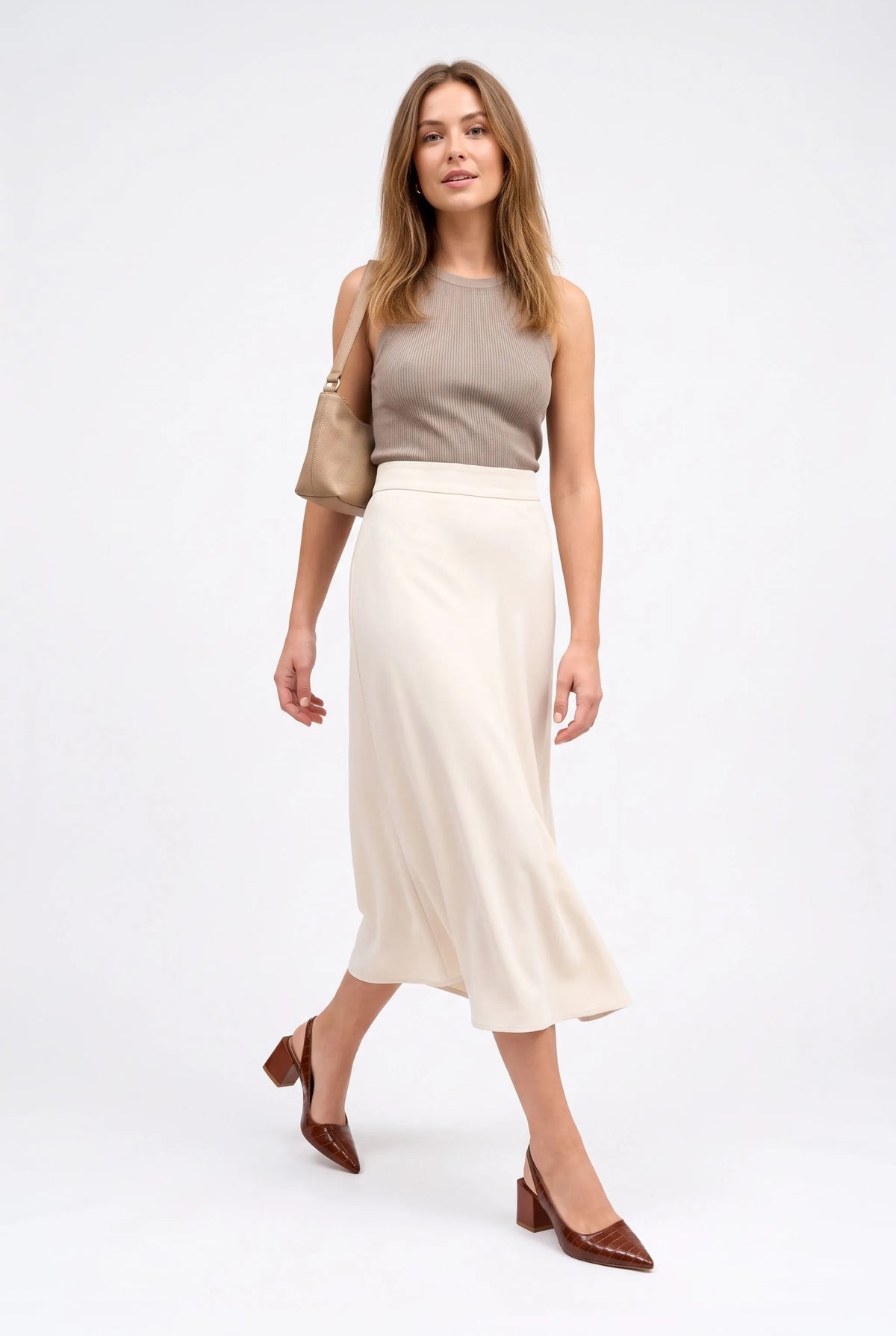 Model walking in brown croc-effect slingbacks with a cream midi skirt, ribbed top and beige shoulder bag 10