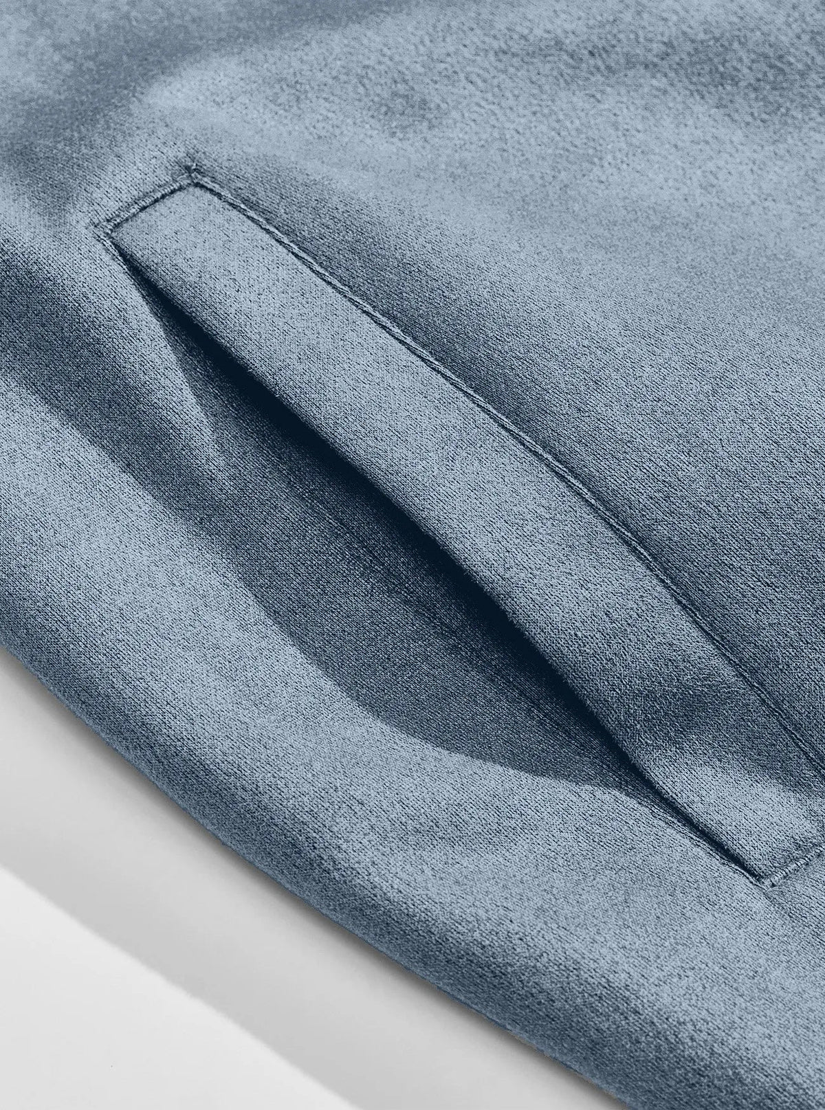 Close-up of the stitched slanted side pocket on light blue suede-look fabric 10