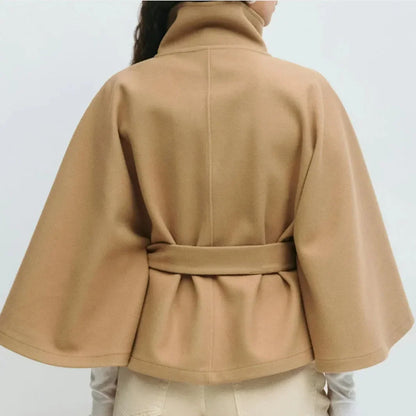 Close back view of the camel cape jacket, showing the centre seam, belt and flared sleeves 10