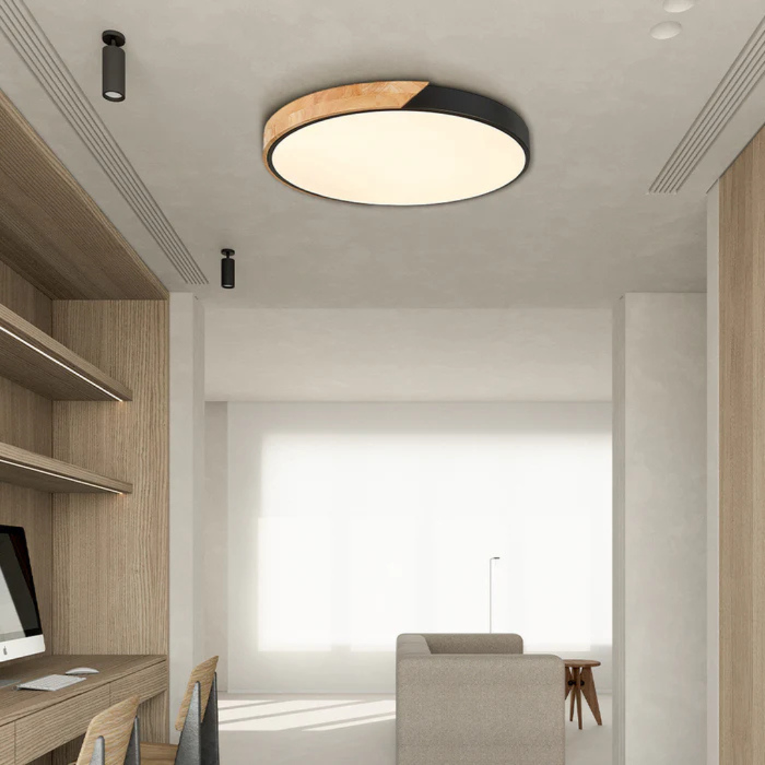 Black and wood round ceiling light in a minimalist study area with wooden shelving and a desk 7