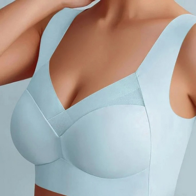 Model wearing the seamless bra in pale blue, front view showing the smooth moulded cups, wide straps and mesh neckline detail. 18