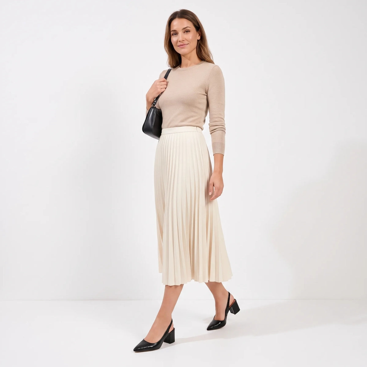 Model walking in black croc-effect slingbacks with a pleated cream skirt, beige jumper and black bag 11
