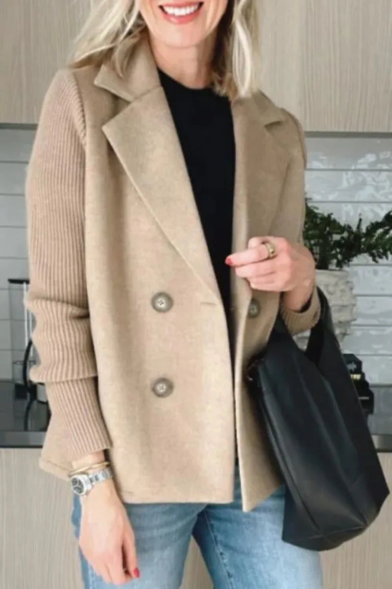 Close-up of beige double-breasted jacket with ribbed sleeves, model holding a black bag 11